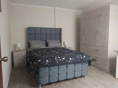 a bedroom with a large blue bed in a room at Departamento Céntrico y Acogedor in Huancayo