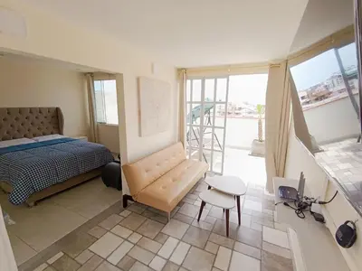 a bedroom with a bed and a chair and a table at Hermoso Penthouse con jacuzzi en terraza in Lima