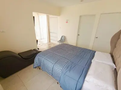 a bedroom with a bed with a blue and white blanket at Hermoso Penthouse con jacuzzi en terraza in Lima