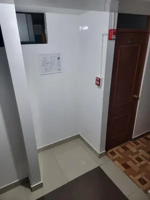 a hallway with a door and a white wall at Hospedaje Escorpio in Lima