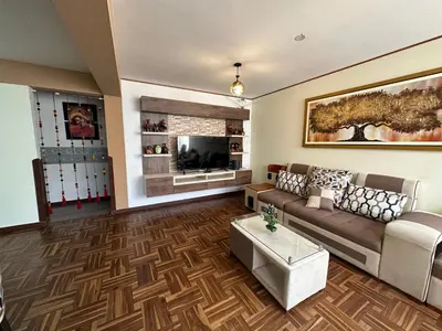 a living room with a couch and a tv at PAKARINA HOUSE in Cusco