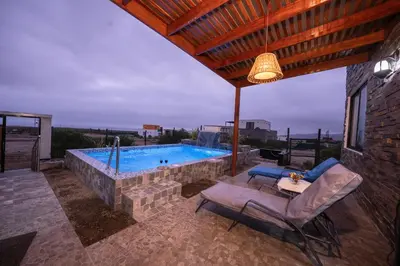 a patio with a swimming pool with a table and chairs at Mar y campo Casa Huarca in La Isla