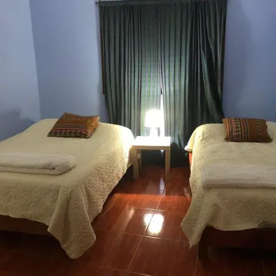 a room with two beds and a window at Pedraza house Airport in Lima