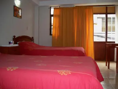 a bedroom with two beds and a window at El Balcon Hostal in Ayacucho