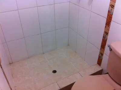 a bathroom with a shower with a drain at El Balcon Hostal in Ayacucho