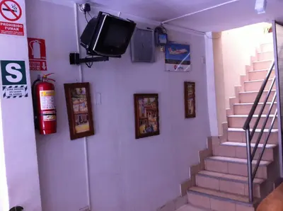 a room with stairs and a tv on a wall at El Balcon Hostal in Ayacucho