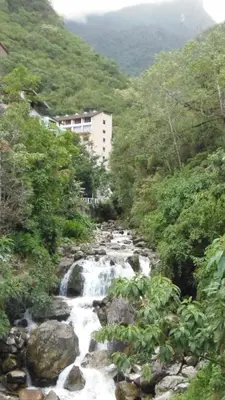 a stream of water flowing down a hill with trees at Hostal Pablo's House in Machu Picchu