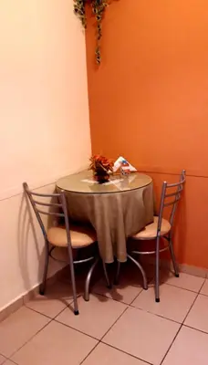 a table with two chairs and a table with flowers on it at Kanata Properties 2 in Lima