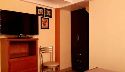 a living room with a television and a chair at Kanata Properties 2 in Lima