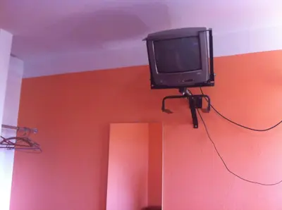 a tv hanging on the corner of a room at Hostal Tres Máscaras in Ayacucho