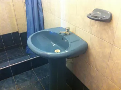 a blue sink in a bathroom with a shower at Hostal Tres Máscaras in Ayacucho
