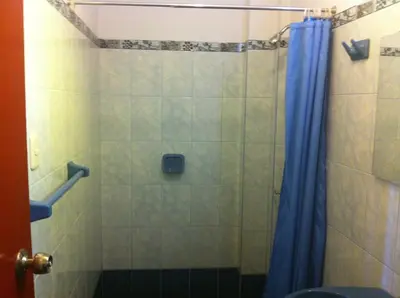 a bathroom with a shower with a blue shower curtain at Hostal Tres Máscaras in Ayacucho