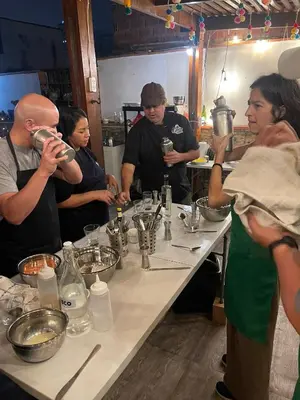 a group of people standing around a table in a kitchen at Casa Huaca in Lima