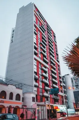 a tall red and white building in a city at Apartamento de Ensueño LINCE in Lima