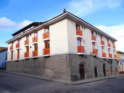 a large white building with orange windows on a street at Hotel San Francisco de Paula Ayacucho in Ayacucho