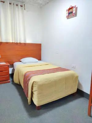 a bedroom with a large bed with a wooden headboard at Hotel San Francisco de Paula Ayacucho in Ayacucho