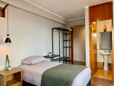 a bedroom with a bed and a sink and a toilet at Casa Encuentro San Blas in Cusco