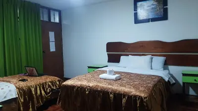 a hotel room with a bed with a candle on it at Sierra Verde - Muy Céntrico Hs in Huancayo