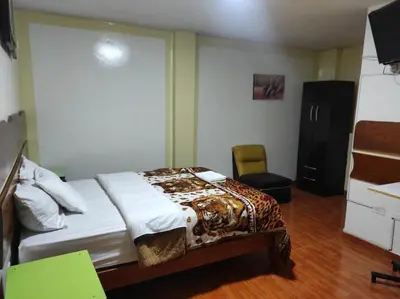 a bedroom with a bed and a chair in it at Sierra Verde - Muy Céntrico Hs in Huancayo