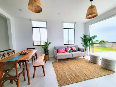 a living room with a couch and a table at HERMOSA CASA CON PISCINA FRENTE AL MAR - PRIMERA FILA in Chincha Baja