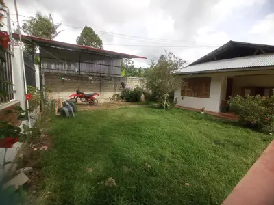 a yard with a motorcycle parked next to a house at Hospedaje Pinky Lodge in Oxapampa