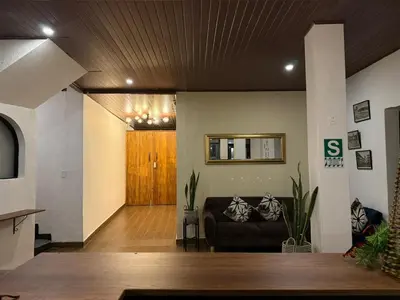 a living room with a couch and a wooden ceiling at Casa Tiyay Cusco in Cusco