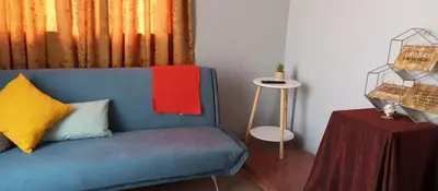 a blue couch sitting in a room with a table at Departamento 5p Tierra del Sol Eterno - Ica centro in Ica