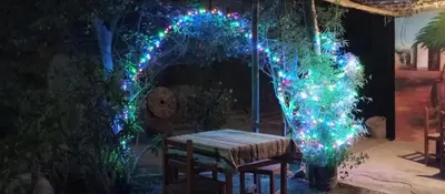 a lit up arch with a picnic table and christmas lights at Departamento 5p Tierra del Sol Eterno - Ica centro in Ica
