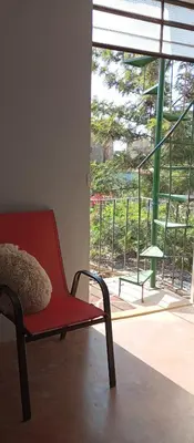 a red chair with a pillow sitting in front of a window at Departamento 5p Tierra del Sol Eterno - Ica centro in Ica