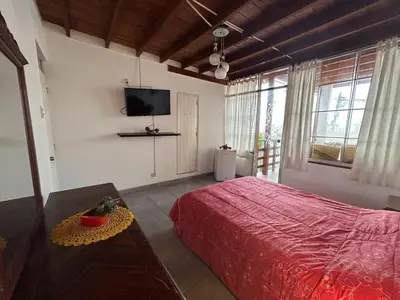 a bedroom with a bed and a tv on the wall at Playa Arica Backpackers in Arica