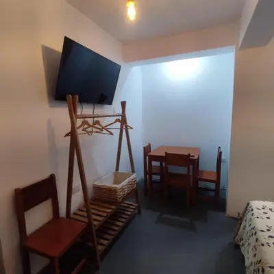 a room with a television and a table and chairs at Hospedaje Hamuy's Lodge in Ica