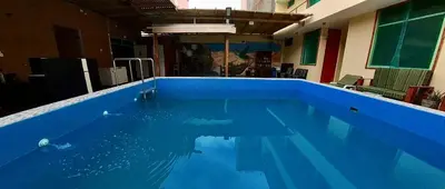 a large blue swimming pool in a building at El Boulevard de Huacachina in Ica