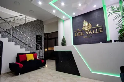 a lobby with a black chair and a sign that reads del value at Hotel del Valle in Huancayo