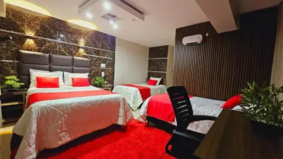 a bedroom with two beds and a red carpet at Hotel del Valle in Huancayo