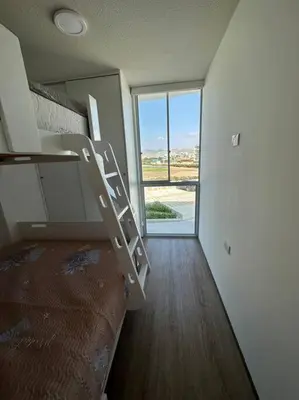 a room with a bunk bed and a window at Apartamento de estreno San Bartolo vista Piscina Playa in San Bartolo