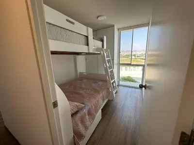 a bedroom with a bunk bed with a ladder at Apartamento de estreno San Bartolo vista Piscina Playa in San Bartolo