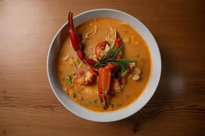 a bowl of soup with carrots and peppers in it at Acari Adventure & ski Resort in Acarí