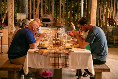 a group of people sitting at a table eating food at Acari Adventure & ski Resort in Acarí