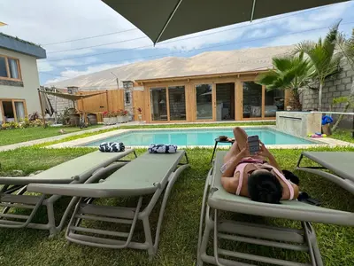 a woman laying on lawn chairs next to a pool at Acari Adventure & ski Resort in Acarí