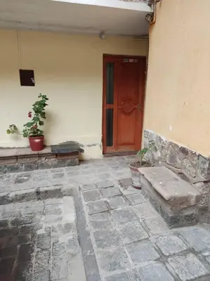 a building with a door and a bench in front of it at Qosqo Apartments 3 in Cusco