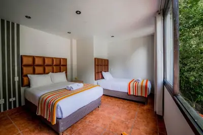 a bedroom with two beds and a window at NaturaLodge Machu Picchu in Machu Picchu