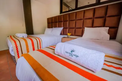 two beds in a hotel room with towels on them at NaturaLodge Machu Picchu in Machu Picchu