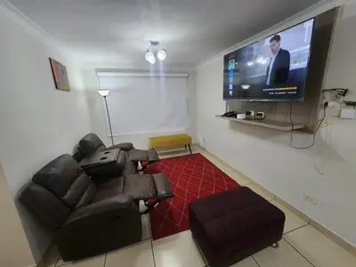 a living room with a couch and a flat screen tv at rodrich business apartment in Lima