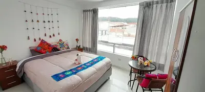 a bedroom with a bed and a large window at Encanta Perú Apartment in Cusco