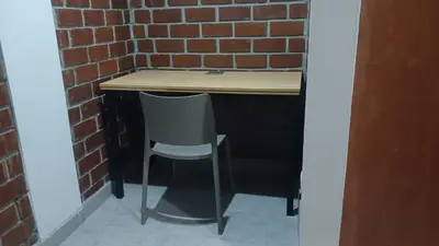 a desk with a chair next to a brick wall at El Valle - Lunahuaná in Lunahuaná