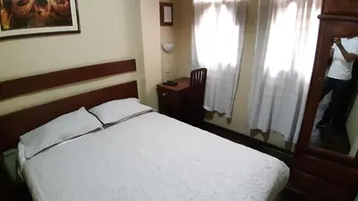 a person taking a picture of a bed in a bedroom at Pretty House Hotel in Lima