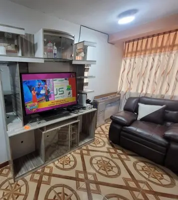a living room with a couch and a flat screen tv at Apartamento en Huancayo in Huancayo