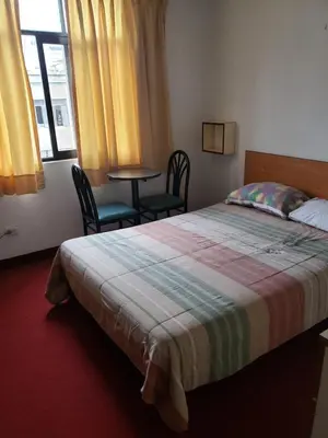 a bedroom with a bed and two chairs and a table at Hospedaje Miraflores 17 in Lima