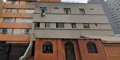 a tall building with windows and a brick building at Hospedaje Miraflores 17 in Lima