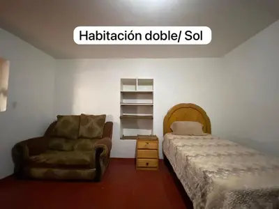 a bedroom with a bed and a chair and a shelf at Casa Katya Cusco in Cusco